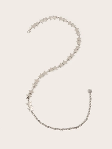 Détail de la ceinture en métal argenté avec étoiles reliées et petit pendentif floral
