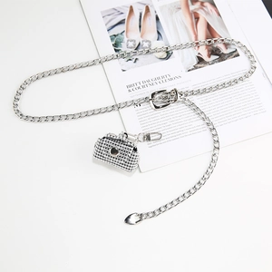 Silver metal chain belt with sparkling rhinestone mini bag pendant on fashion magazine
