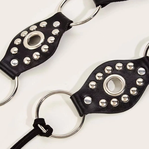 Y2K punk style black leather belt featuring silver metal O-rings and round rivets