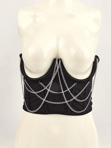 Detail of black satin corset top featuring silver metal chain mesh and boning structure