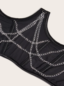 Detail of black corset vest featuring decorative silver metal chains and ring buckles