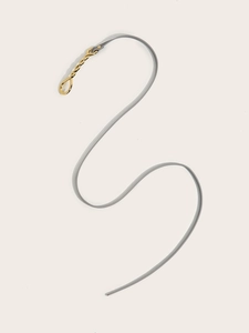 Close-up of minimalist light grey leather thin belt with elegant gold spiral metal buckle