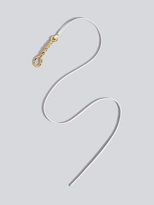 Close-up of white leather waist belt featuring a twisted gold metal hook buckle