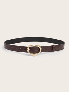 Détail d'une boucle coeur dorée sur une ceinture en cuir marron à motif crocodile