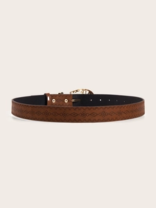 Detail of vintage brown textured belt with ethnic geometric patterns and gold carved buckle