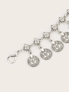 Detailed close-up of retro silver chain belt with coin charms and floral metal links