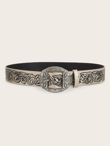 Macro view of vintage engraved metal buckle and floral pattern on champagne leather belt