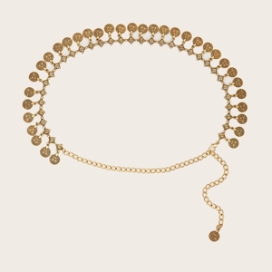 Detailed macro shot of vintage gold metal waist chain with embossed coin pendants