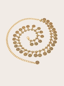Close-up detail of golden metal waist chain with vintage bohemian embossed coin pendants