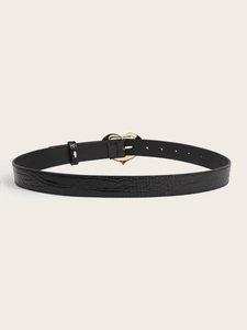 Détail d'une ceinture noire en cuir croco avec boucle dorée en forme de cœur