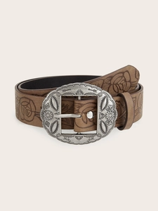 Detail of vintage brown belt with floral embossing and retro silver geometric buckle
