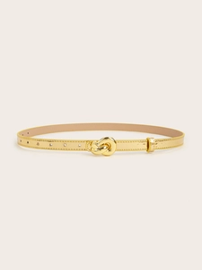 Detail of slim gold waist belt featuring a trendy metal knot buckle and adjustable eyelets