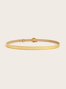 Close-up of golden thin belt with polished oval buckle and detailed stitching for women
