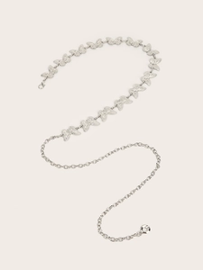 Detail of silver vintage waist chain featuring butterfly-shaped metal links and lobster clasp