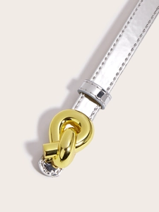 Close-up of textured silver thin belt featuring a stylish gold metal twist buckle detail