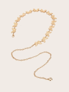 Close-up of golden vintage belt chain featuring detailed metal butterfly links and rings