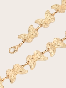 Close-up of golden metal butterfly chain with detailed relief and lobster clasp