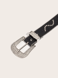 Makro-Detail des schwarzen Krokogürtels mit silberner Strass-Schnalle und Wellenmuster