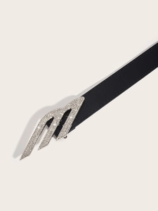 Detailed view of women's black leather belt featuring a large silver rhinestone M buckle