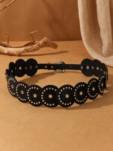 Detail of vintage black PU leather belt with silver rivets, eyelets and engraved buckle