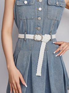 Detail of white braided leather belt with silver oval buckle on blue denim dress