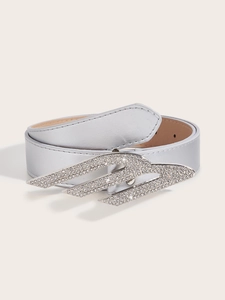 Detailed close-up of a silver rhinestone buckle featuring vintage wing design and metal belt