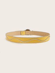 Detail van gele punk riem met krokodillenstructuur en zilveren metalen stud versieringen