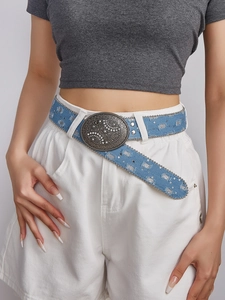 Detail van blauwe denim riem met bloemige strass gesp en metalen versieringen
