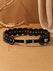 Close-up of vintage black leather belt with silver studs and western engraved buckle details