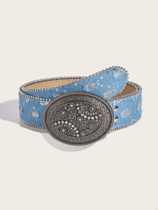 Detail van vintage denim riem met sierlijke zilveren gesp, strass en kraalranden
