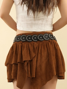 Detail of vintage black leather belt with silver hollow rings and studs on brown suede skirt