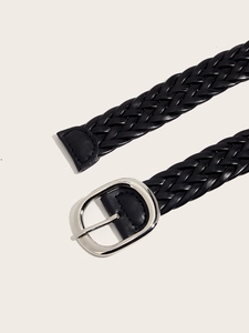 Detail of black braided leather belt featuring a silver oval metal pin buckle and texture