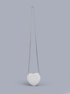 Close-up of heart-shaped mini crossbody bag in white faux leather with silver snake chain