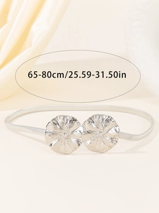 Détail de la ceinture élastique argentée avec boucle à double fleur et échelle de taille