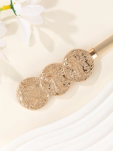 Detailed view of golden elastic spring waist belt with three embossed metal discs decoration