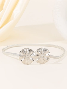 Détail d'une ceinture élastique argentée en métal avec boucle double fleur pour robes