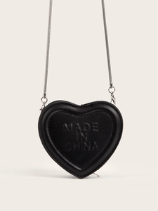 Close-up of heart-shaped black mini bag with silver chain and embossed detail