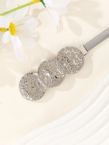Macro shot of silver metal waist belt featuring engraved circular buckle and woven chain