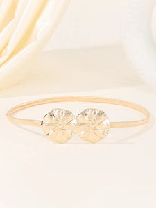 Détail de la ceinture dorée en métal élastique avec boucle à motif de double fleur