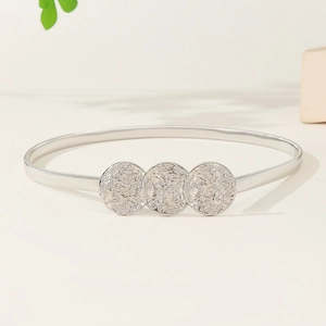 Elastic silver metal belt for women with three textured vintage round discs on light background