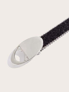 Gros plan sur une ceinture noire pailletée avec boucle ovale argentée et bordure perlée