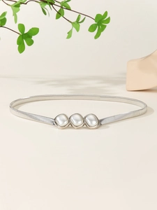 Détail de ceinture élastique argentée avec boucle décorative à trois perles nacrées