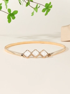Detail view of a gold elastic metal belt with white marble texture diamond ornaments