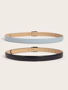 Detail view of skinny PU leather belts for women with gold buckles in black and light blue