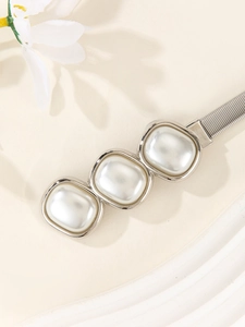 Détail d'une ceinture élastique en métal avec trois perles carrées et bordure argent