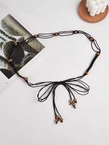 Détail de la ceinture bohème Y2K en corde noire tressée avec perles en bois