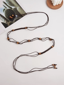 Détail d'une ceinture bohème Y2K tissée à la main avec des perles en bois naturel