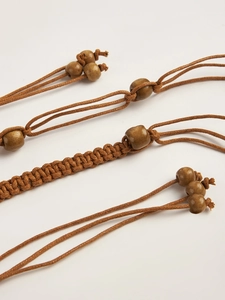 Détail de la ceinture bohème Y2K avec corde tressée marron foncé et perles en bois
