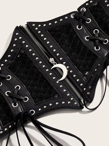 Detail of gothic lace corset belt with metal rivets, zipper, and silver crescent moon pendant