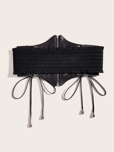 Detail of black punk corset belt with metal zipper and skull charms on elastic fabric